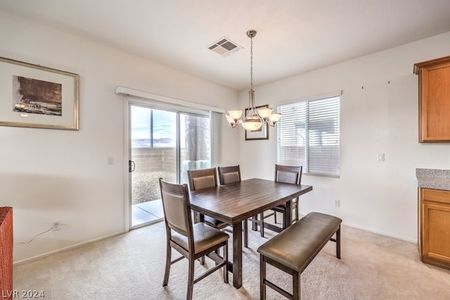 carpeted dining space with an inviting chandelier