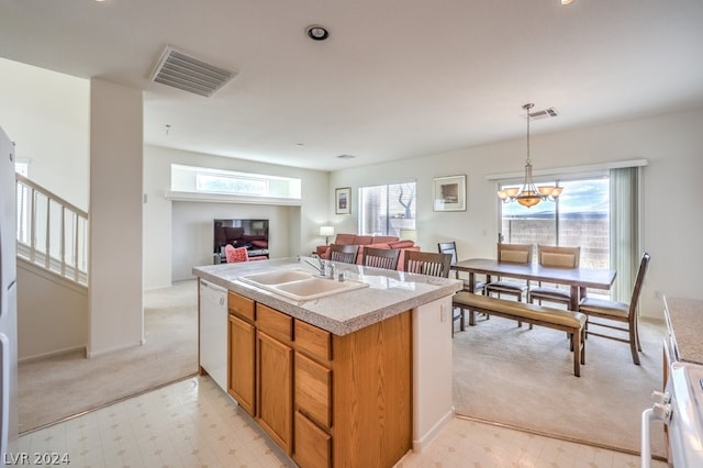 kitchen featuring decorative light fixtures, sink, light tile floors, white dishwasher, and a chandelier