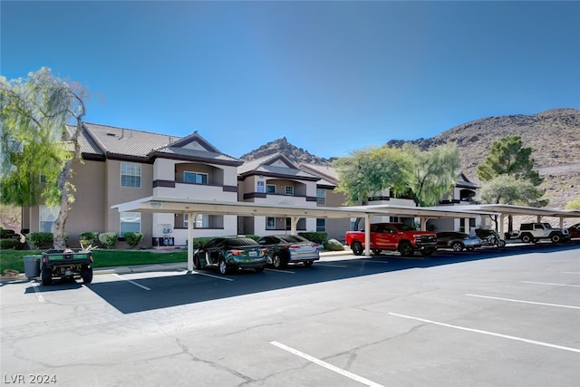 view of parking / parking lot with a carport and a mountain view