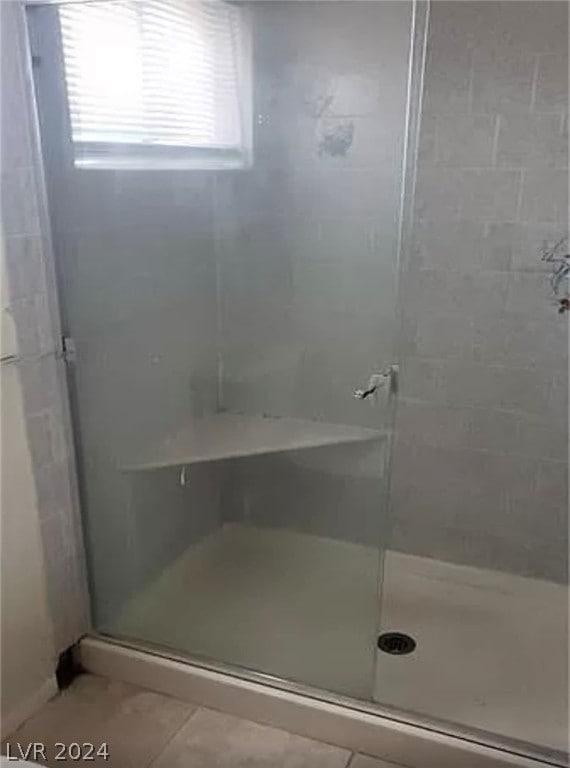 bathroom featuring an enclosed shower and tile floors