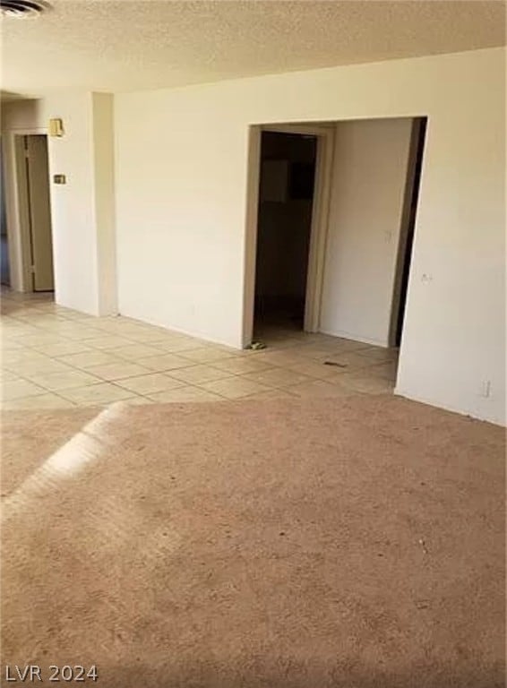 carpeted empty room featuring a textured ceiling