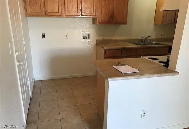 kitchen with light tile flooring, stove, custom exhaust hood, and sink