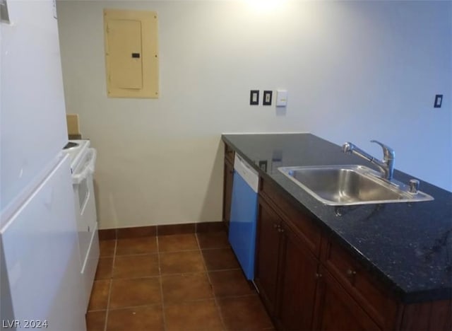 kitchen with dark stone counters, white appliances, sink, dark brown cabinets, and dark tile floors