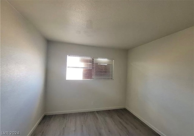 spare room with dark hardwood / wood-style flooring and a textured ceiling