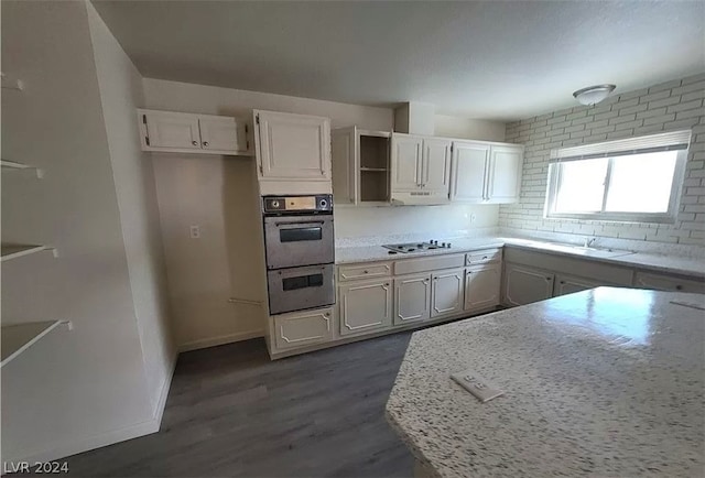 kitchen featuring backsplash, stainless steel double oven, dark hardwood / wood-style floors, and gas cooktop