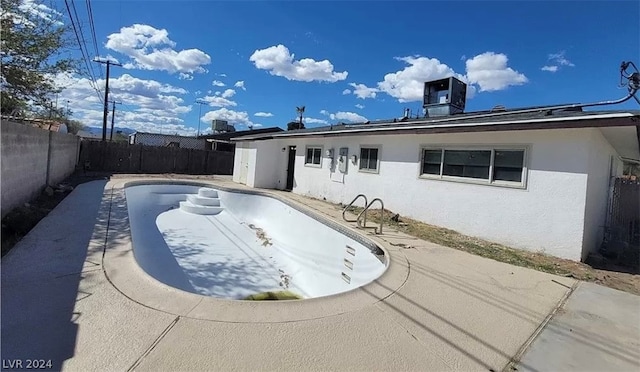 view of swimming pool with central AC and a patio