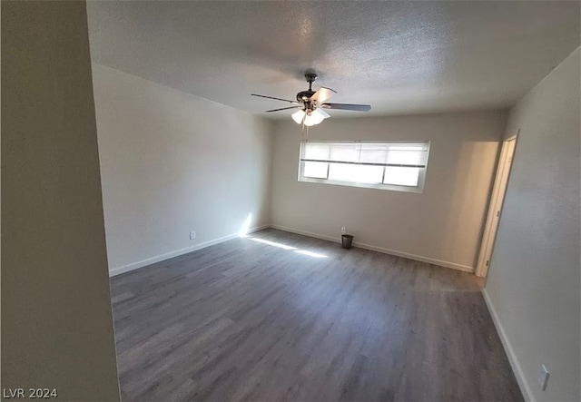 spare room with dark hardwood / wood-style floors, a textured ceiling, and ceiling fan