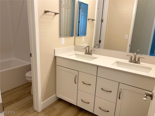 full bathroom featuring  shower combination, vanity, hardwood / wood-style floors, and toilet