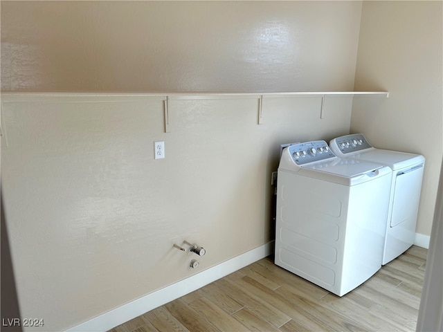 laundry room featuring light hardwood / wood-style floors and washing machine and dryer