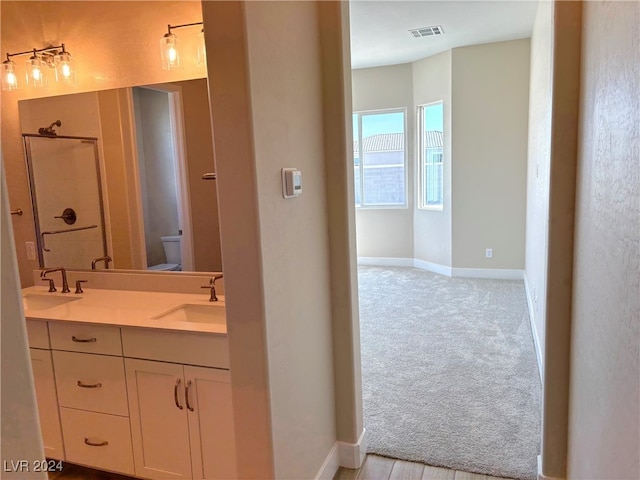 bathroom featuring vanity, toilet, and a shower