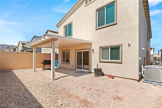 rear view of house with central AC unit and a patio