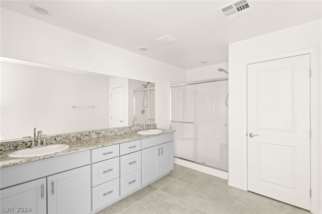 bathroom with walk in shower, dual sinks, tile flooring, and oversized vanity