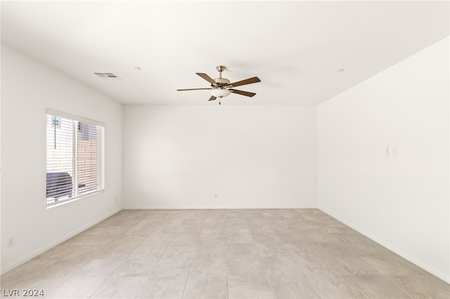 tiled spare room featuring ceiling fan