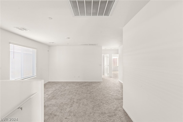 unfurnished room featuring light carpet