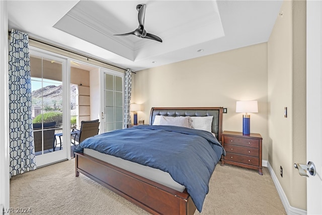 carpeted bedroom featuring ceiling fan, access to outside, a raised ceiling, and french doors