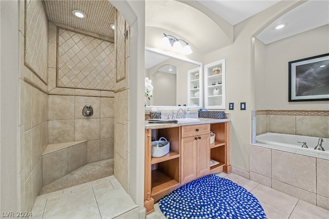 bathroom featuring vanity with extensive cabinet space, tile flooring, and separate shower and tub