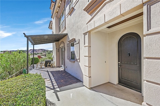 view of exterior entry featuring a patio