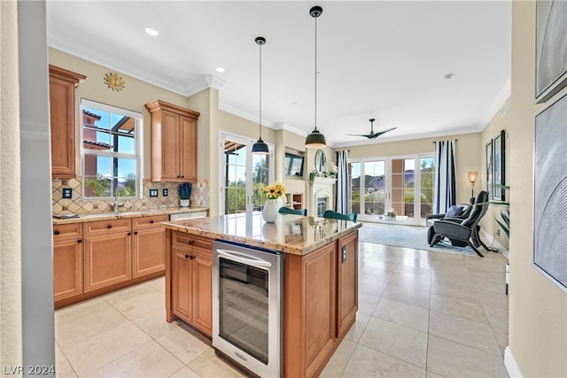 kitchen featuring a kitchen island, wine cooler, a wealth of natural light, and pendant lighting