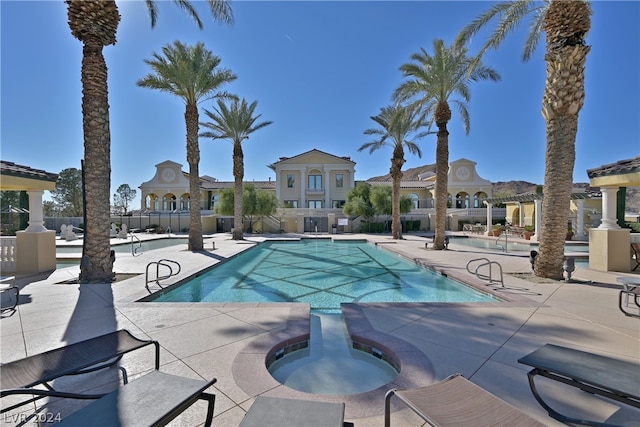 view of pool featuring a patio area and a hot tub