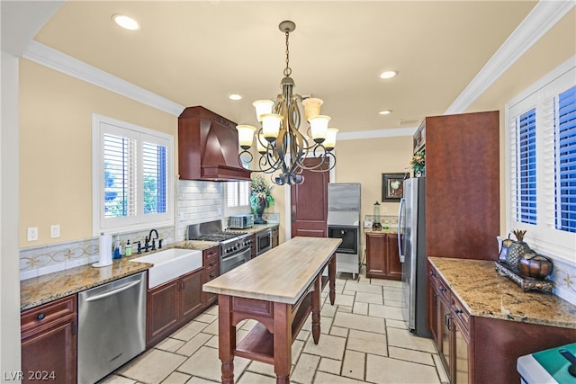 kitchen with custom exhaust hood, tasteful backsplash, appliances with stainless steel finishes, sink, and an inviting chandelier