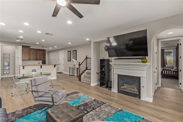 living room with ceiling fan and light hardwood / wood-style flooring