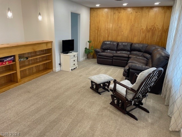 living room featuring light carpet and wood walls