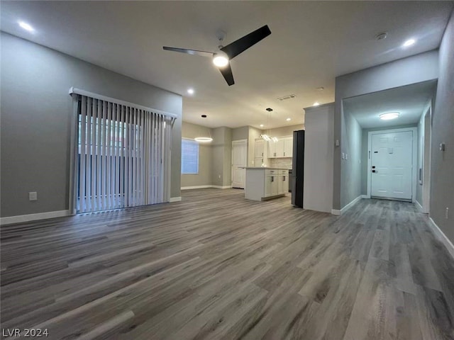 unfurnished living room with ceiling fan and hardwood / wood-style floors