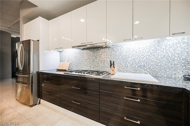 kitchen featuring appliances with stainless steel finishes, tasteful backsplash, light tile floors, dark brown cabinets, and white cabinets