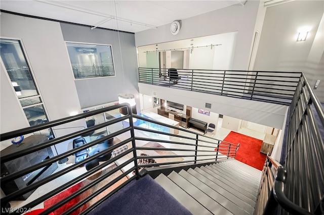 staircase featuring a high ceiling and wood-type flooring