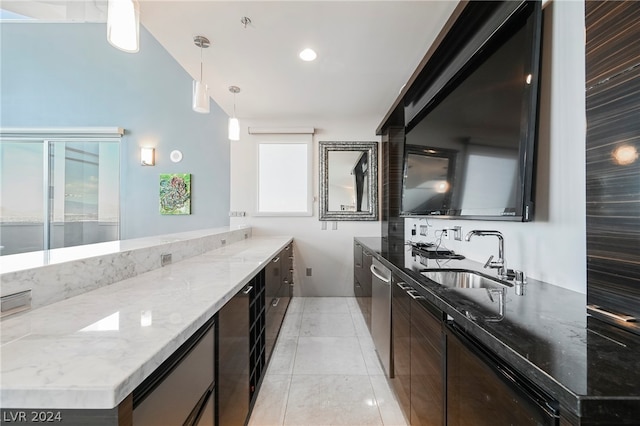 kitchen featuring light tile floors, light stone countertops, hanging light fixtures, dishwasher, and sink