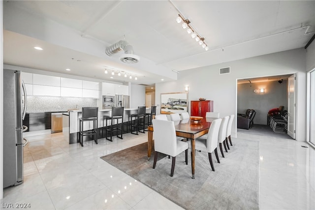 dining area featuring track lighting and light tile floors