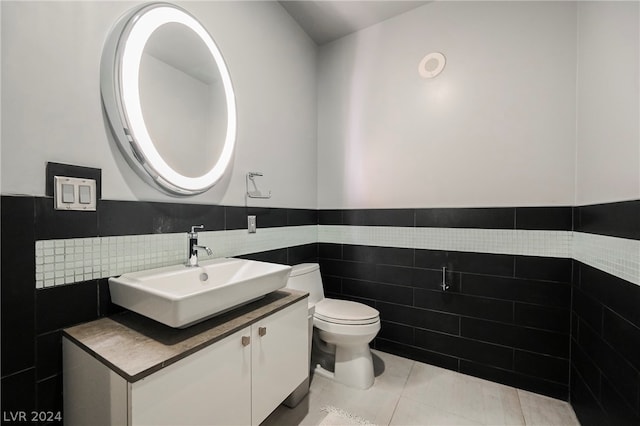 bathroom featuring toilet, vanity, tasteful backsplash, tile walls, and tile flooring