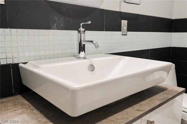 bathroom featuring sink and tile walls