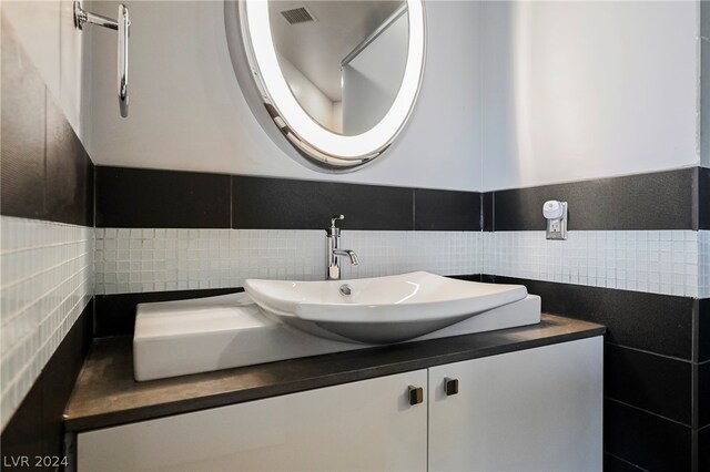 bathroom with backsplash, tile walls, and vanity