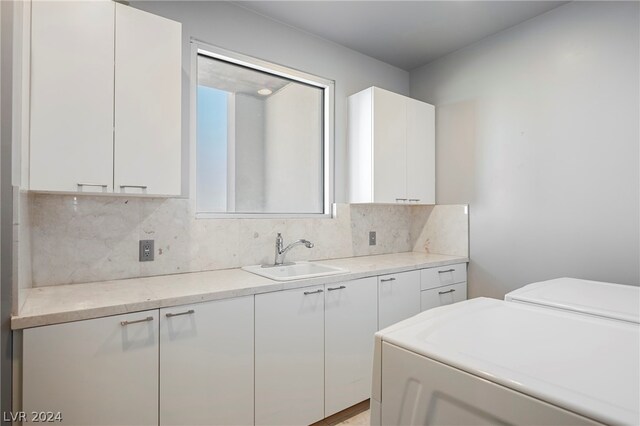 laundry area with washer and dryer, cabinets, and sink