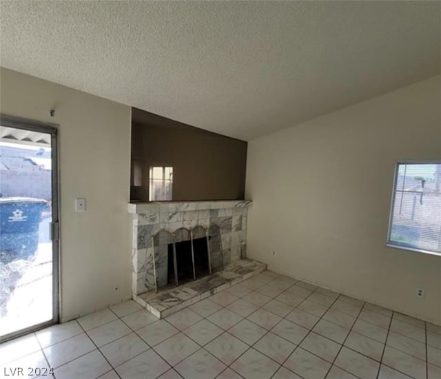 unfurnished living room featuring a fireplace, light tile floors, and plenty of natural light