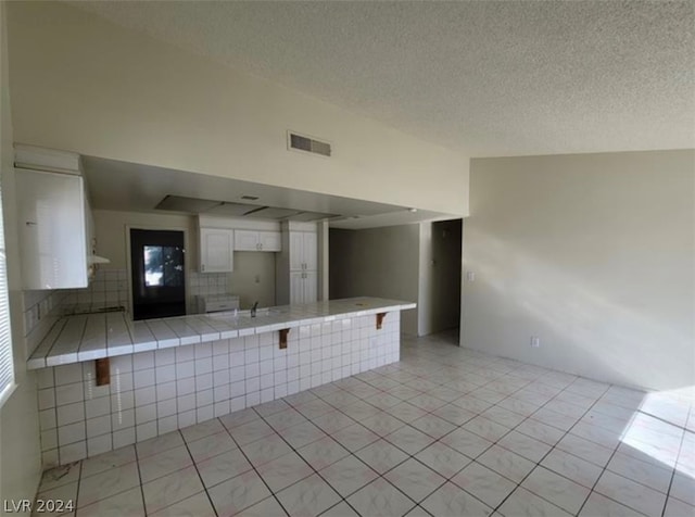 spare room featuring light tile floors, a textured ceiling, and sink