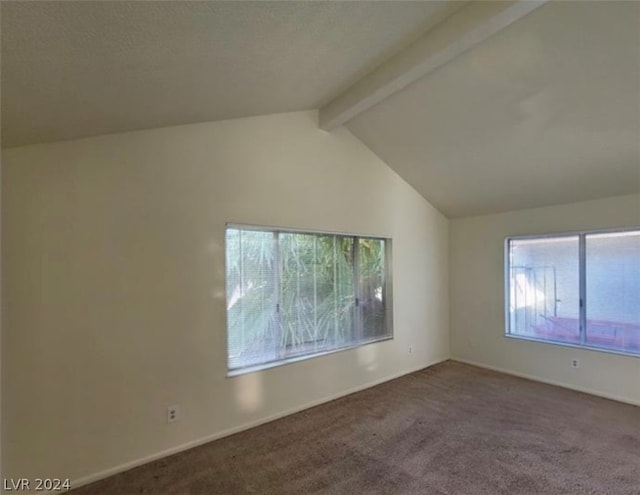 carpeted spare room with plenty of natural light and vaulted ceiling with beams