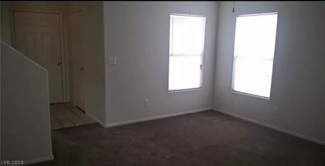 empty room featuring dark colored carpet