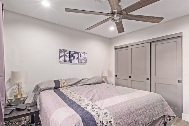 bedroom featuring a closet, light wood-type flooring, and a ceiling fan