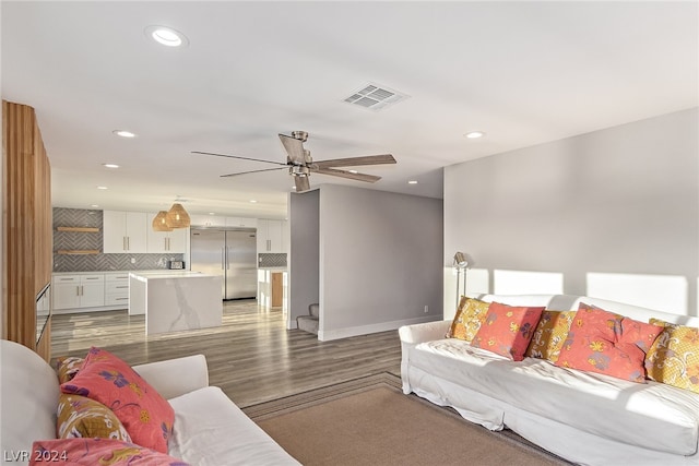 living room featuring ceiling fan, light wood finished floors, visible vents, and recessed lighting