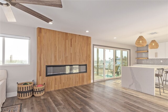 living room featuring light wood-style floors, plenty of natural light, visible vents, and recessed lighting