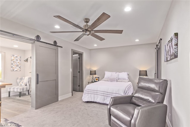 bedroom with a barn door, baseboards, light colored carpet, and recessed lighting