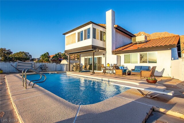 back of property with a fenced in pool, a patio area, fence, and stucco siding