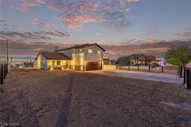 view of front of house with concrete driveway, fence, an attached garage, and stucco siding