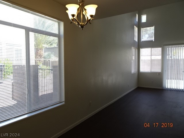 unfurnished room featuring a chandelier