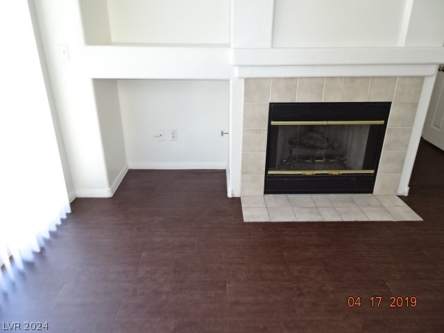 room details with a tile fireplace and light hardwood / wood-style floors