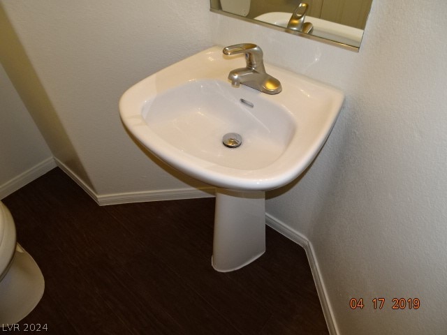 bathroom with toilet and hardwood / wood-style flooring