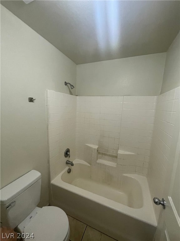 bathroom with tiled shower / bath, toilet, and tile patterned floors