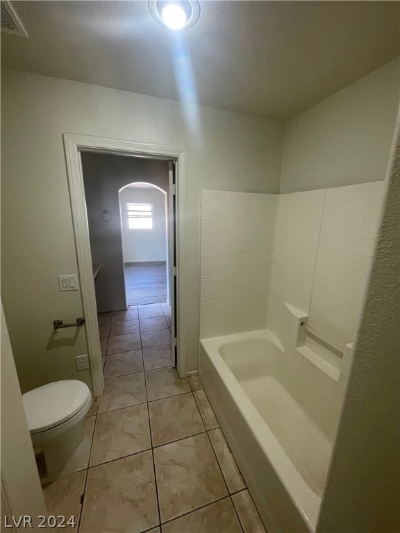 bathroom featuring toilet, washtub / shower combination, and tile patterned flooring